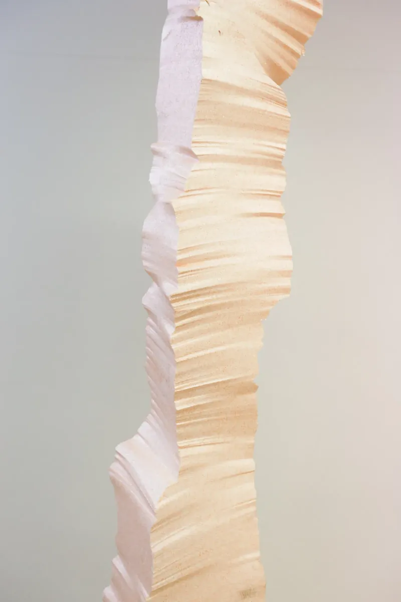 Close view of a pale, layered column with warm light on its edges