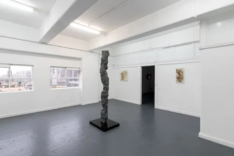Wide view of the gallery with the column and works by Lina Buck and Garth Howells on the walls