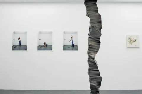 Close view of the column against a wall of small framed photographs