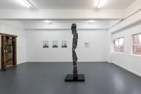 The column in the gallery with framed works behind