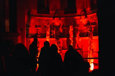 Silhouetted crowd before the columns in the red church