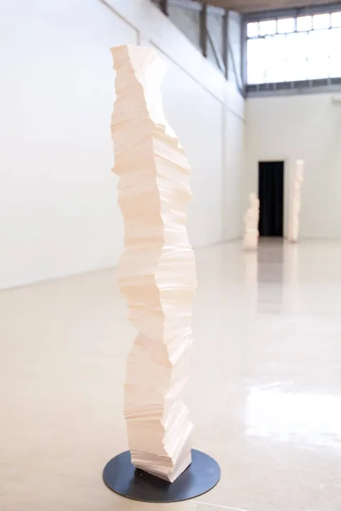 A tall white polystyrene column on a dark round base