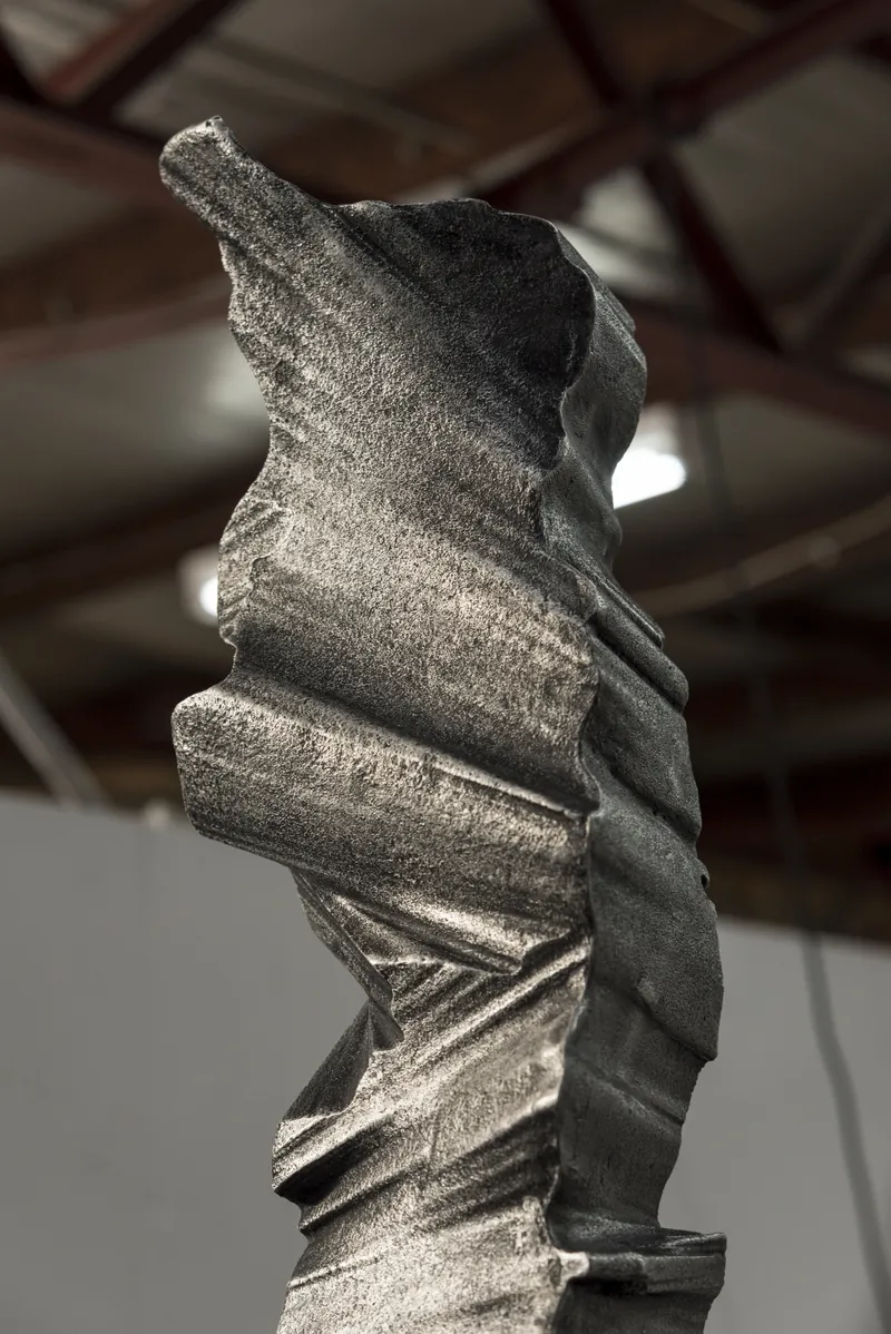 A column photographed in the workshop under exposed roof trusses
